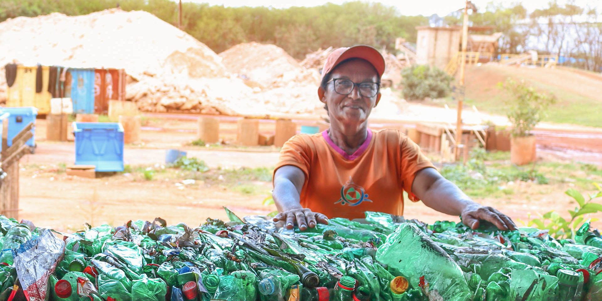 Catarina apoiada em garrafas plásticas destinadas à reciclagem