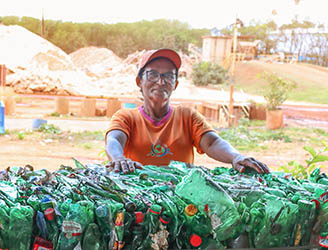 Catarina apoiada em garrafas plásticas destinadas à reciclagem